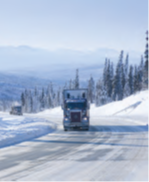 Truck driving on a snowy highway.